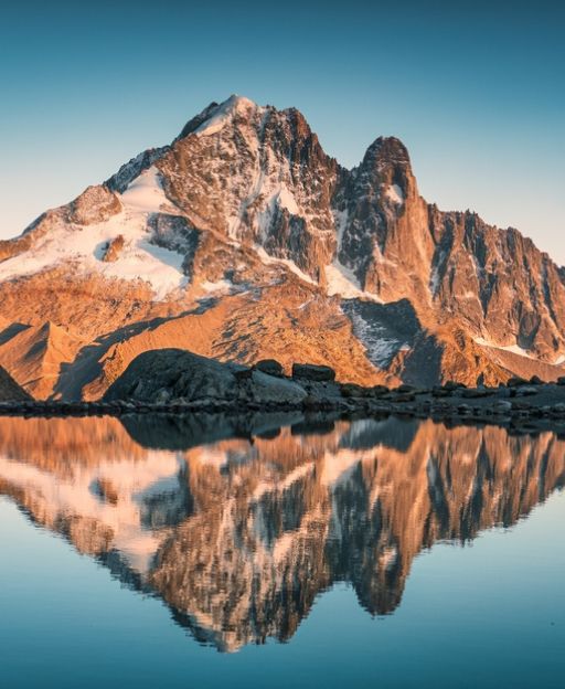 Lac Blanc in the French Alps with the Mont Blanc massif reflected in the still alpine lake at golden hour