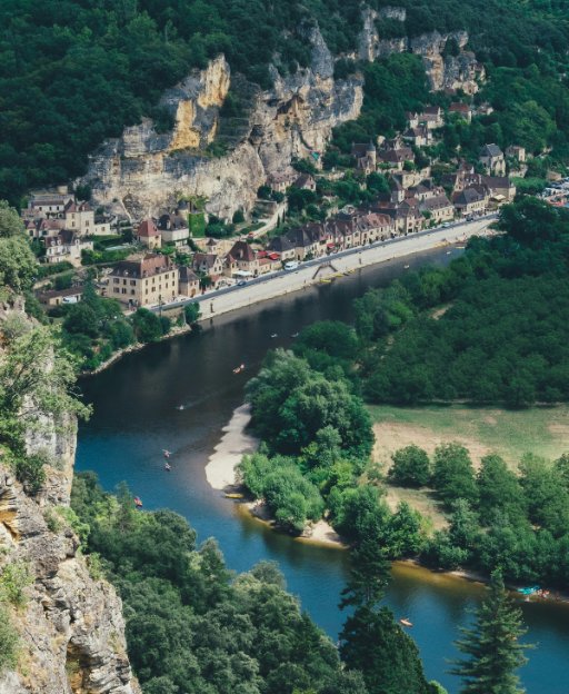Aerial view of the Dordogne River winding through limestone cliffs and a medieval village, France