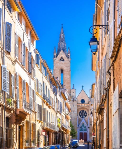 Charming street scene in Aix-en-Provence, France, with cafés and boutique shops lining a sunny pedestrian street