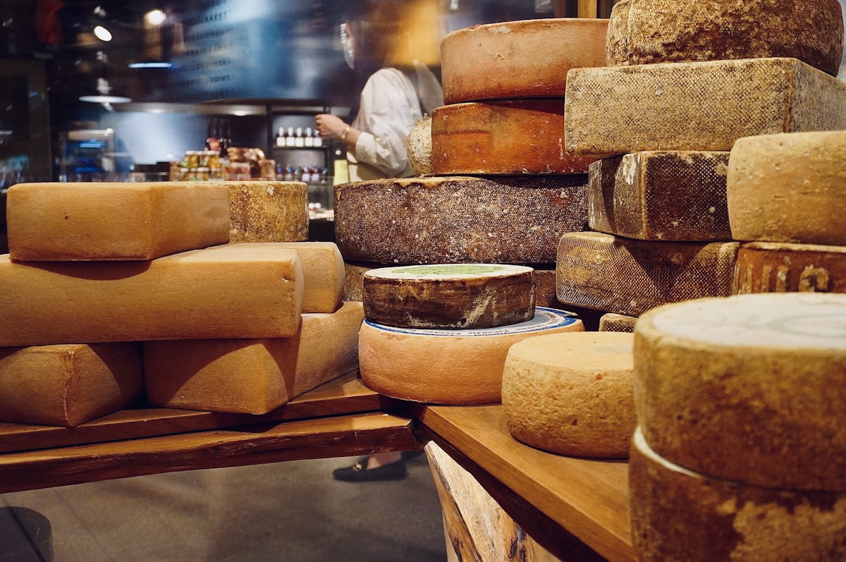 Various wheels and blocks of aged cheese displayed at a French market stall