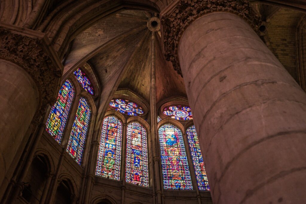 Stained glass windows and stone columns inside a Gothic cathedral in Reims