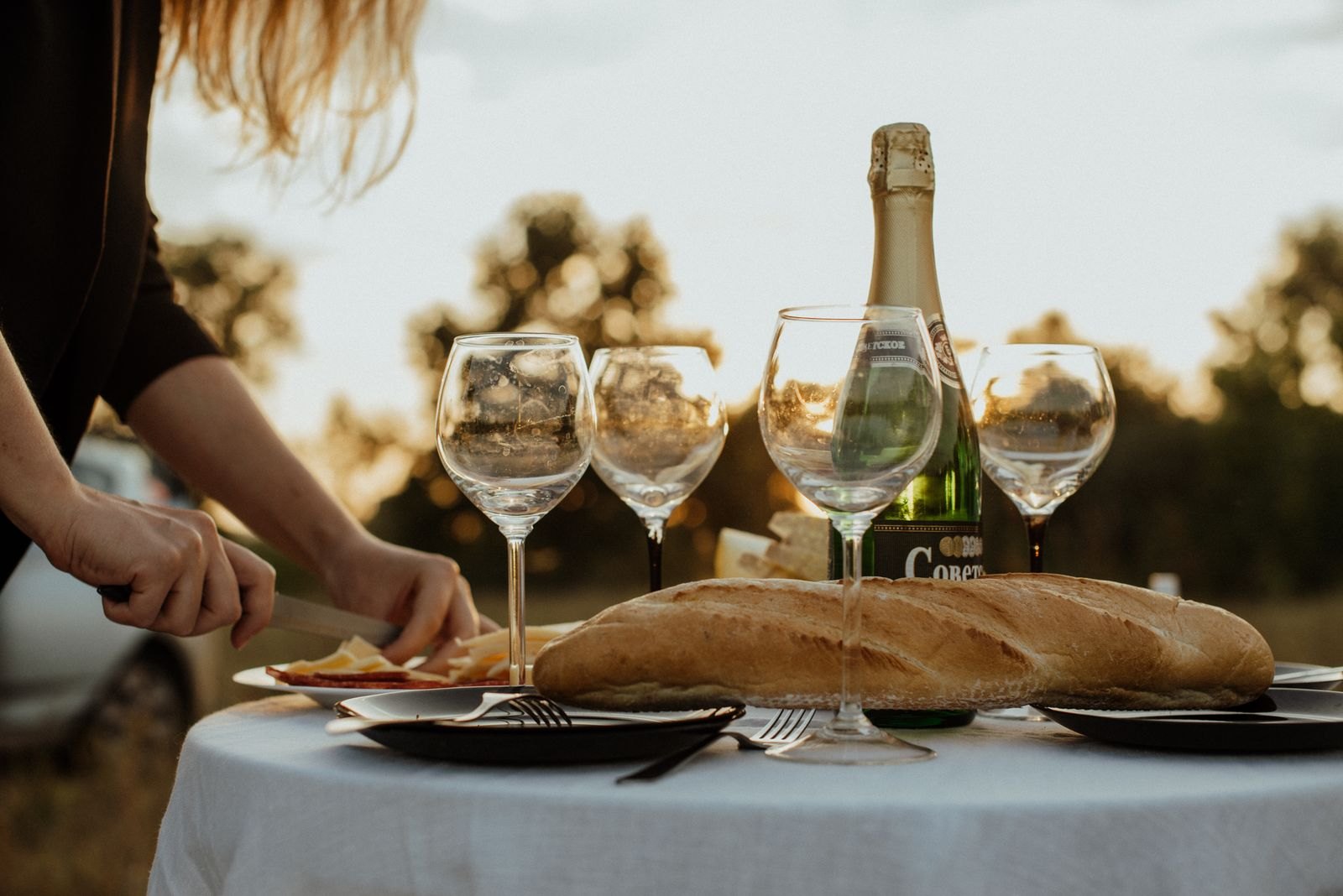 Table laid with a baguette and wine glasses
