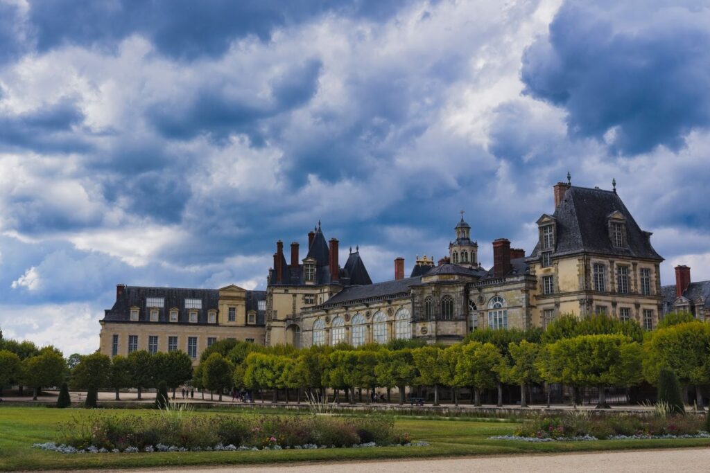 Château de Fontainebleau and its gardens under a cloudy sky