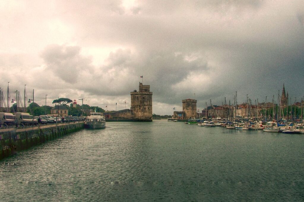 Tour Saint-Nicolas and Tour de la Chaîne at the harbour mouth of La Rochelle under a grey sky