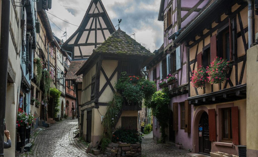 A narrow cobbled street of half-timbered houses in Eguisheim, Alsace