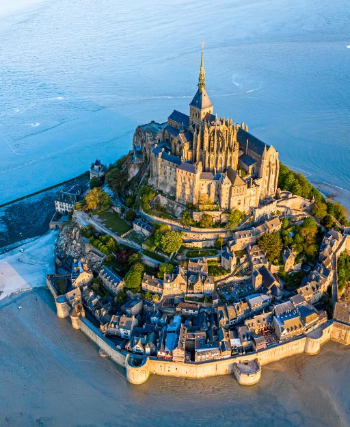 Aerial view of Mont Saint-Michel island abbey rising from the bay at golden hour, Normandy, France