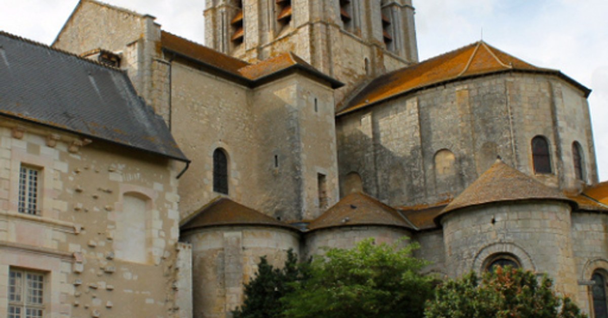 Romanesque stone abbey with golden roof domes and bell tower